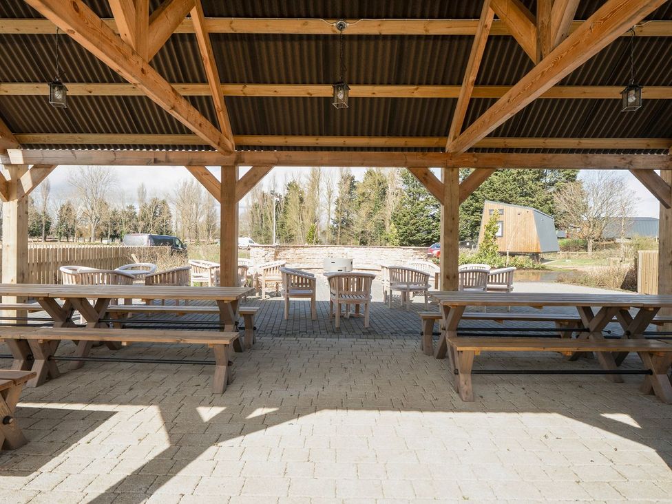 An outdoor seating area with wooden tables and chairs at Brookside Bliss - Billing Aquadrome