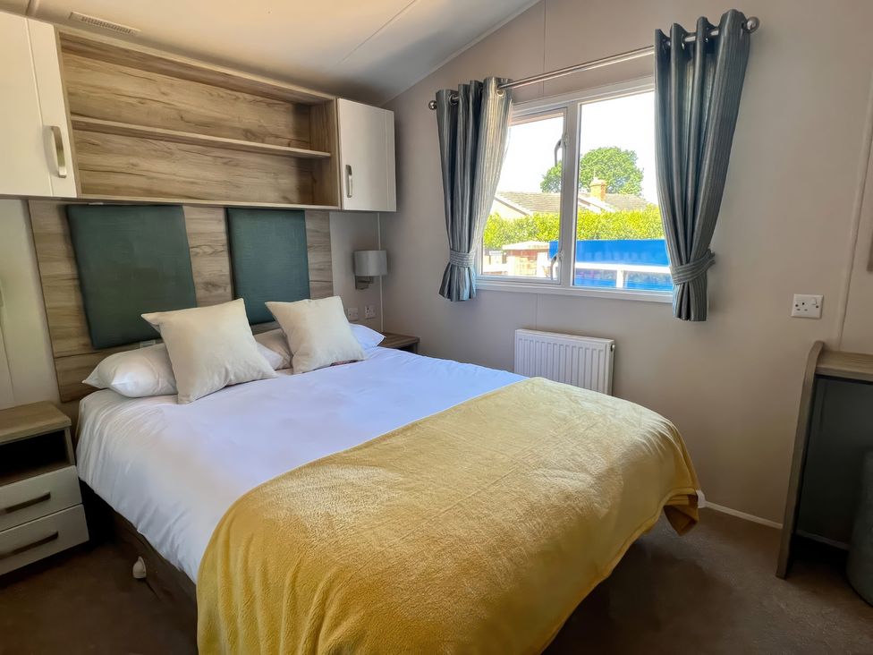 A bedroom with a bed and shelf at Seagull's Sanctuary - Hayling Island