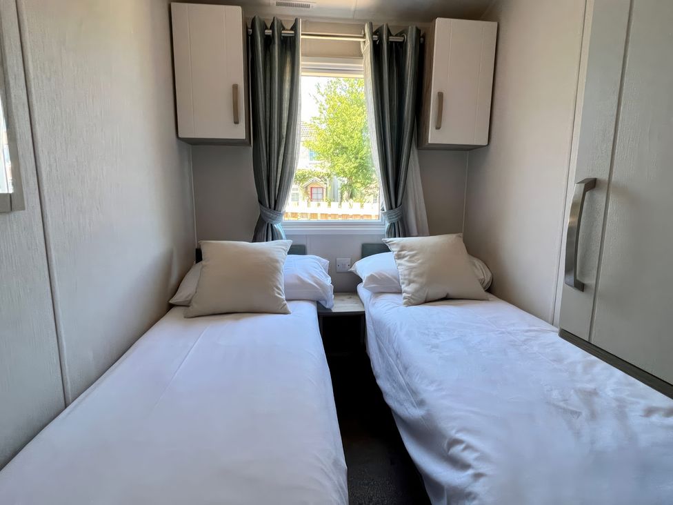 A bedroom with two single beds at Seagull's Sanctuary - Hayling Island