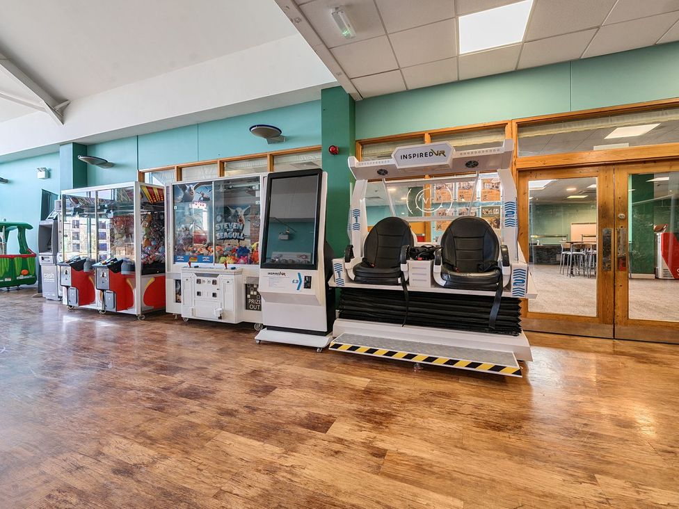A game room with claw machines and virtual reality seats at Mariners Meadow Hayling Island Holiday Park