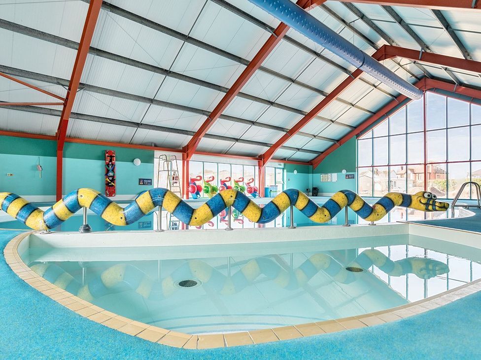 An indoor swimming pool area with a snake-shaped pool divider and large windows at Mariners Meadow Hayling Island