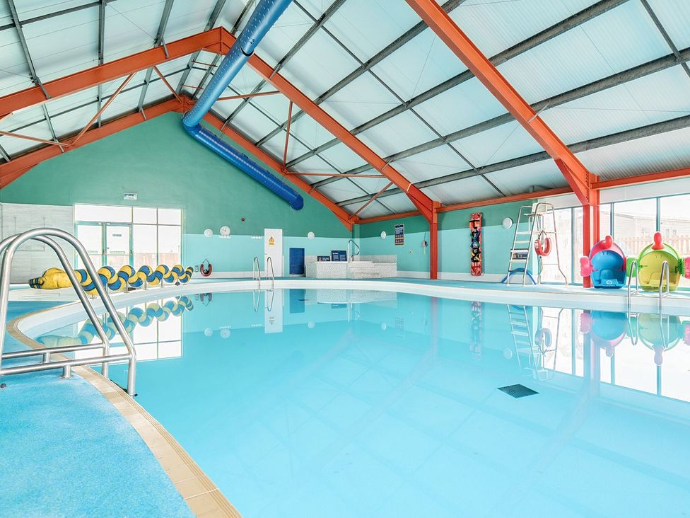 An indoor swimming pool with slides and pool equipment at Mariner's Meadow - Hayling Island Hayling Island Holiday Park
