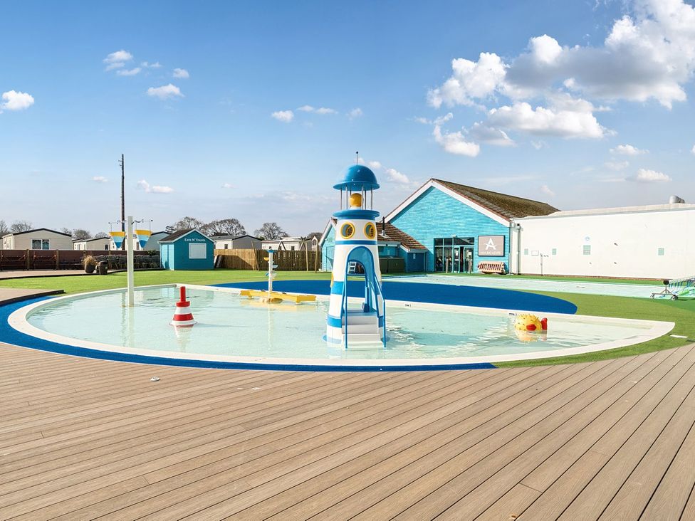 A children's splash pool with a lighthouse slide and play features at Seaside Serenity - Hayling Island Holiday Park