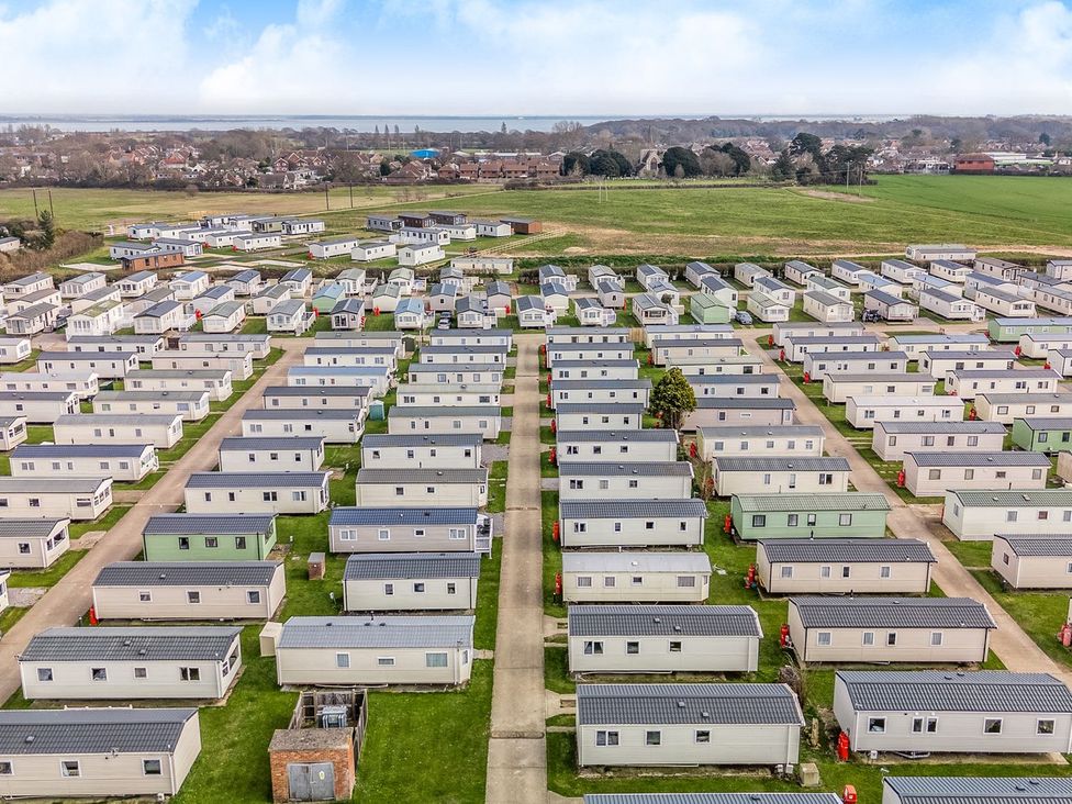 A large holiday park with rows of static caravans and green open fields at Seaside Serenity - Hayling Island in Hayling Island Holiday Park