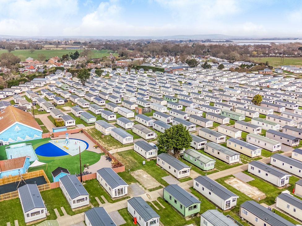 An aerial view of a holiday park with rows of static caravans and a small pool area at Seaside Serenity - Hayling Island in Hayling Island Holiday Park
