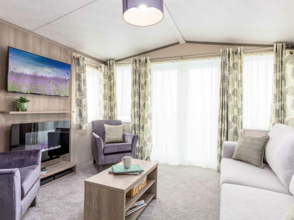A living room with a sofa and armchairs at Sandy Shores - Hayling Island