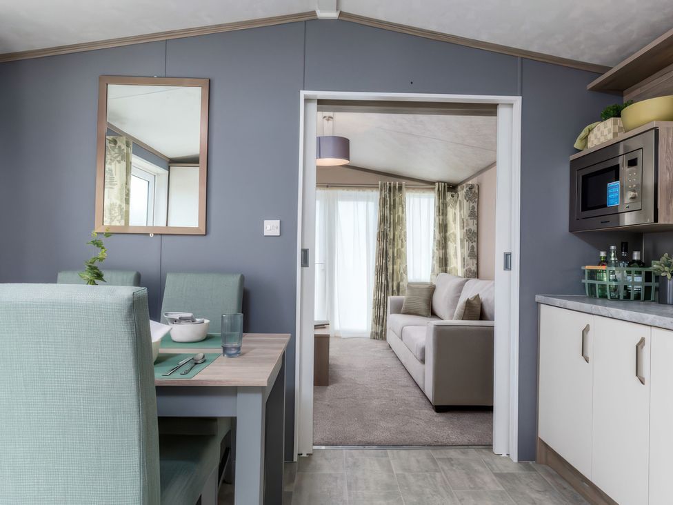 A dining area with a table and chairs at Sandy Shores - Hayling Island