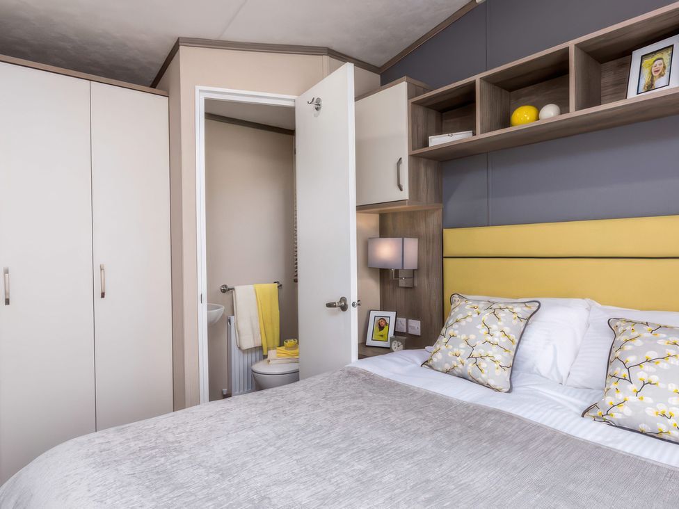 A bedroom with a bed and shelf at Sandy Shores - Hayling Island