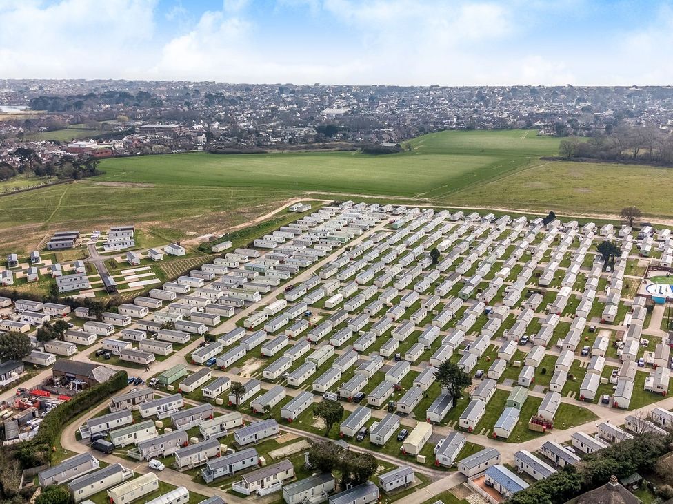 A large holiday park with many caravans arranged in rows and fields in the background at Island Breeze - Hayling Island in Hayling Island Holiday Park