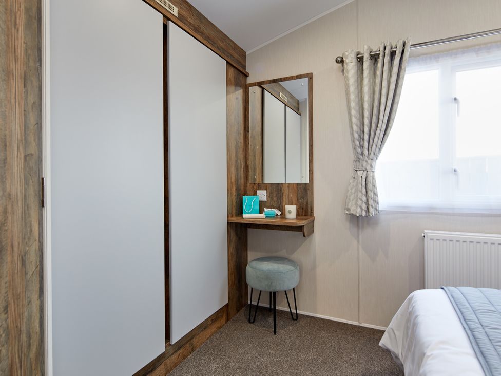 A bedroom with a vanity table and mirror at Island Breeze - Hayling Island