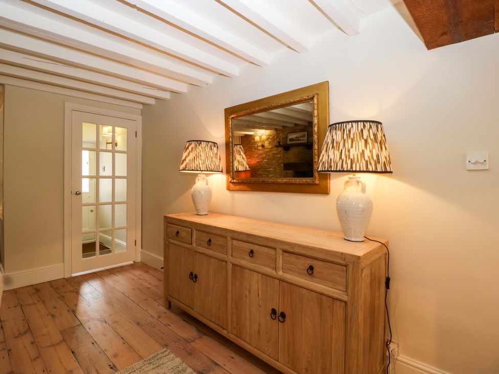 A hallway with a console table and a mirror at The Cottage in Stow-On-The-Wold