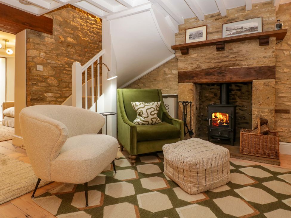A living room with a fireplace and seating at The Cottage in Stow-On-The-Wold