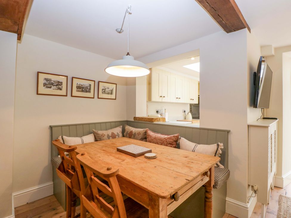 A dining room with a wooden table and chairs at The Cottage in Stow-On-The-Wold