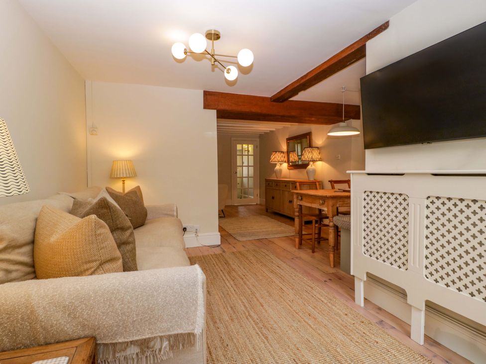 A living room with a sofa and dining area at The Cottage in Stow-On-The-Wold