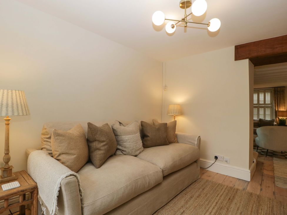 A living room with a sofa and lamp at The Cottage in Stow-On-The-Wold