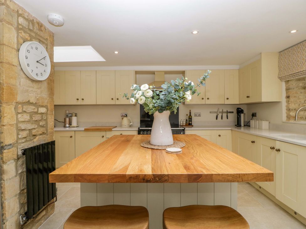 A kitchen with a wooden island and sink at The Cottage in Stow-On-The-Wold
