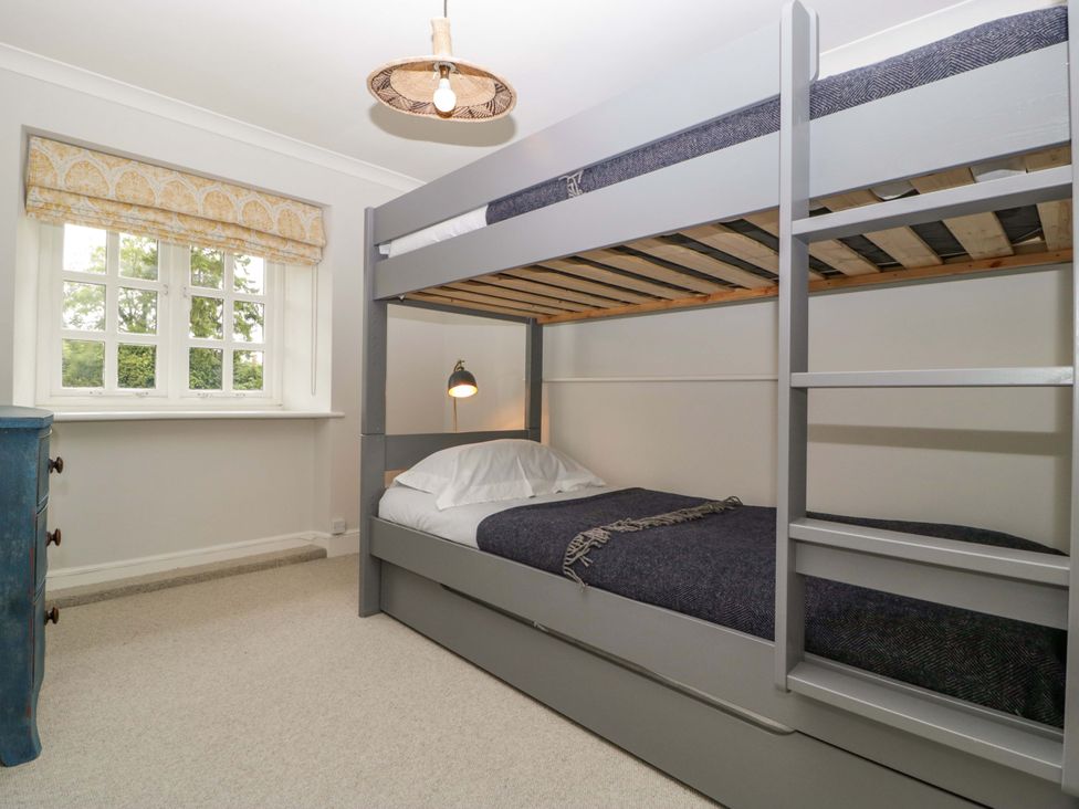A bedroom with a bunk bed and a single bed at The Cottage in Stow-On-The-Wold