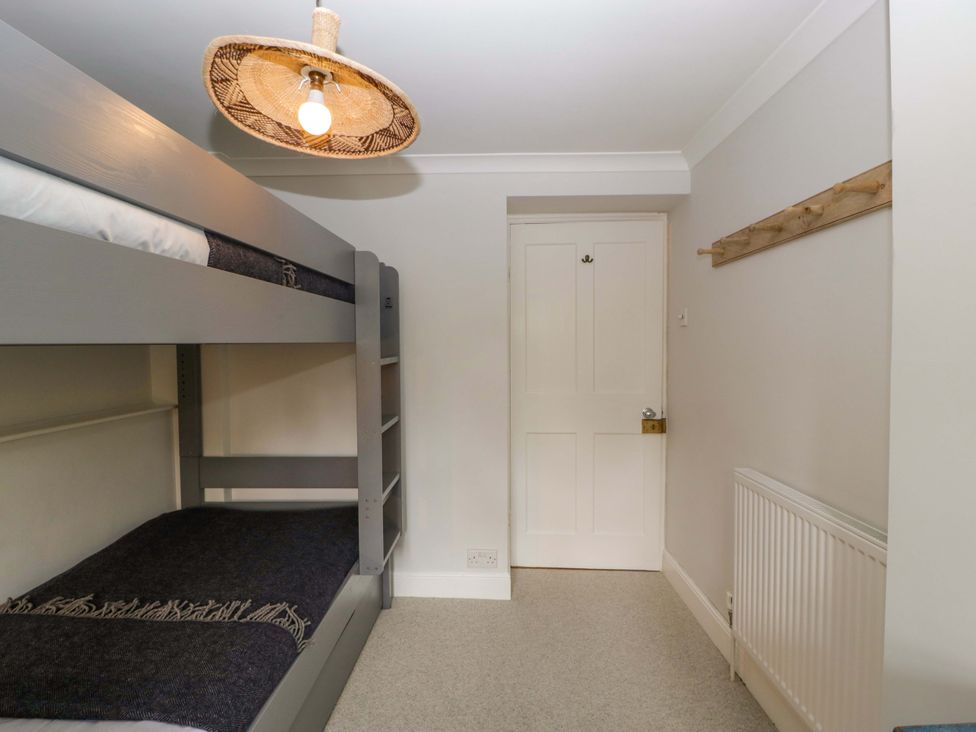 A bedroom with a bunk bed and a door at The Cottage in Stow-On-The-Wold