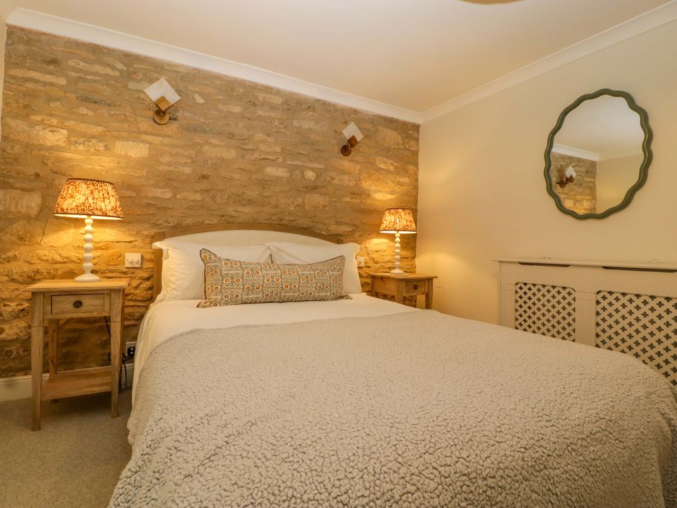A bedroom with a bed and bedside table at The Cottage in Stow-On-The-Wold