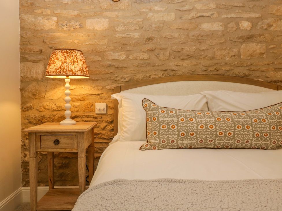 A bedroom with a bed and bedside table at The Cottage in Stow-On-The-Wold