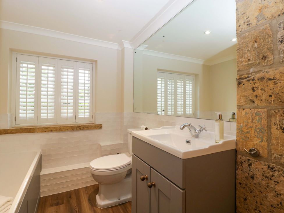 A bathroom with a sink, toilet, and bath tub at The Cottage Stow-On-The-Wold