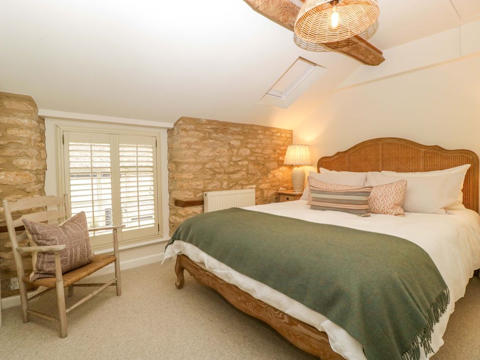 A bedroom with a bed and chair at The Cottage Stow-On-The-Wold