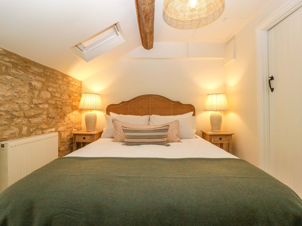 A bedroom with a bed, nightstands, and lamps at The Cottage in Stow-On-The-Wold