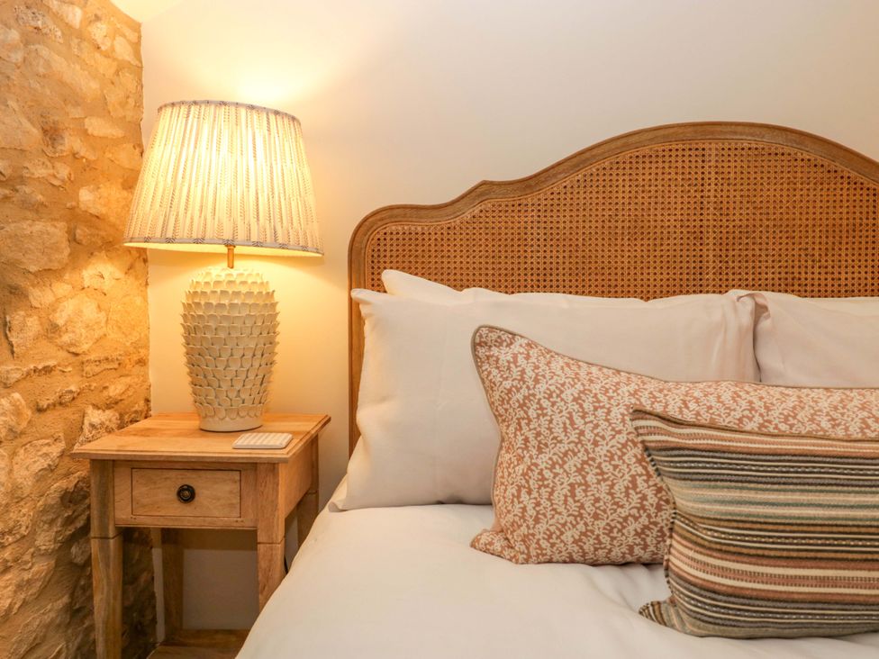 A bedroom with a bed and bedside table at The Cottage in Stow-On-The-Wold