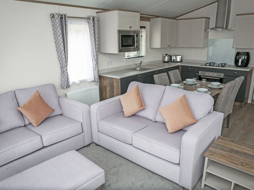 A living room with furniture and kitchen units at Wave Whisperers - Hayling Island Holiday Park