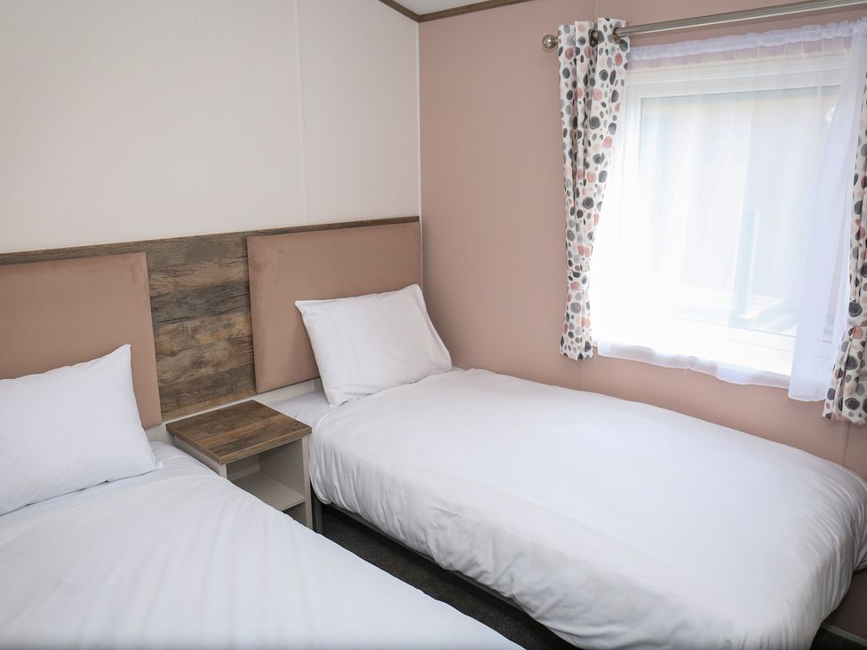 A bedroom with two beds and a window at Wave Whisperers - Hayling Island Holiday Park