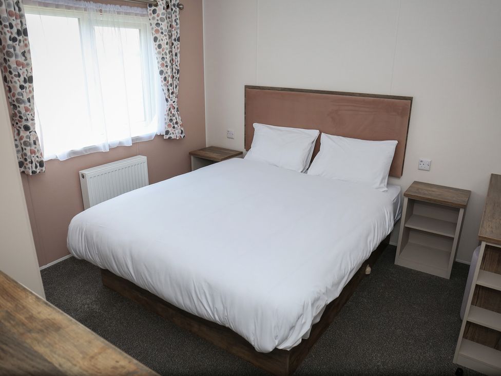 A bedroom with a double bed and nightstands at Wave Whisperers - Hayling Island