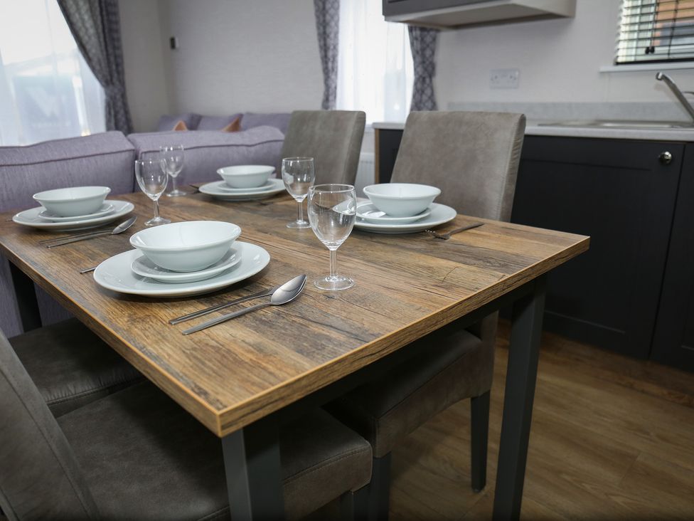 A dining room with a table set for four at Wave Whisperers - Hayling Island