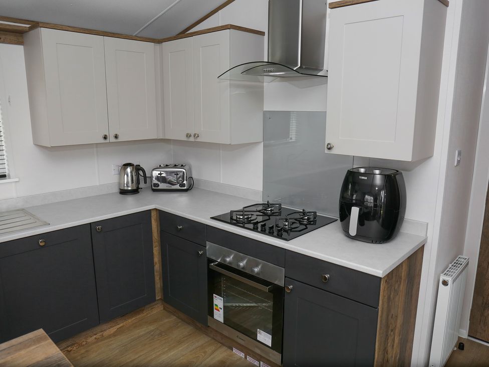 A kitchen with a gas stove and appliances at Wave Whisperers - Hayling Island