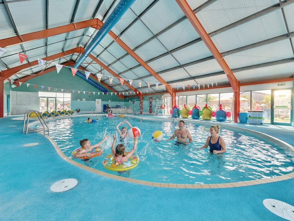 A swimming pool with children and adults playing at Dune Delight - Hayling Island