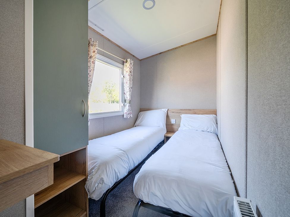 A bedroom with two single beds a window and a wardrobe at Sunset Sands - Hayling Island in Hayling Island Holiday Park