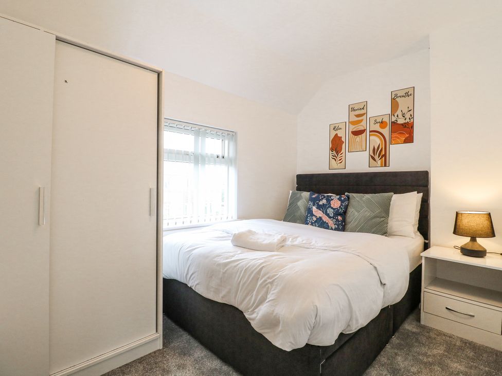 A bedroom with a bed a bedside table with a lamp a wardrobe and artwork on the wall at 46 Dalby Road Antsey