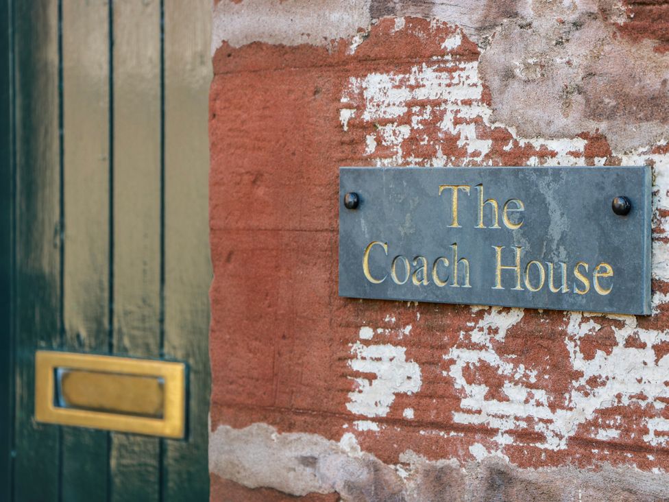 A sign on a wall indicating The Coach House at The Old Coach House Lockerbie