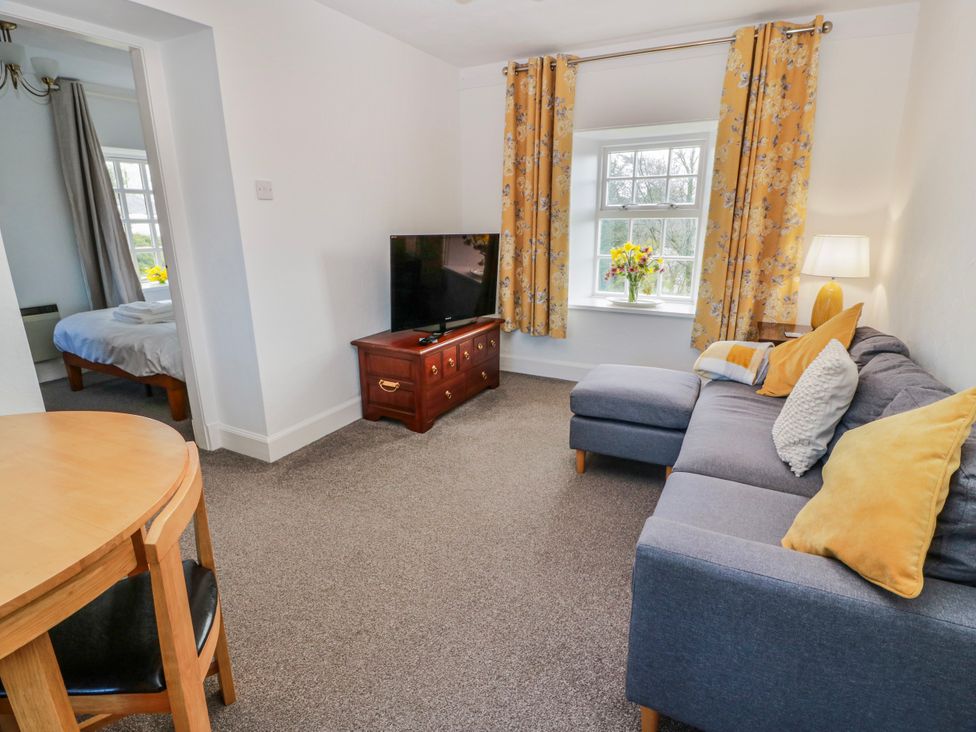 A living room with a sofa and television at The Old Coach House Lockerbie