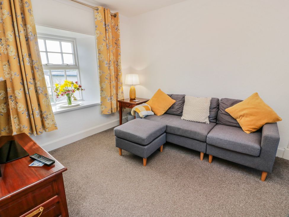 A living room with a sofa and lamp at The Old Coach House in Lockerbie