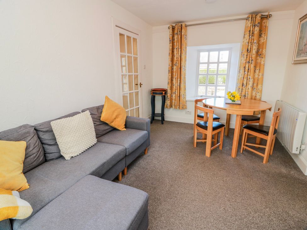 A living room with a sofa and dining table at The Old Coach House in Lockerbie