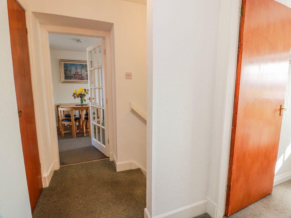 A hallway leading to a dining area with a table and chairs at The Old Coach House in Lockerbie
