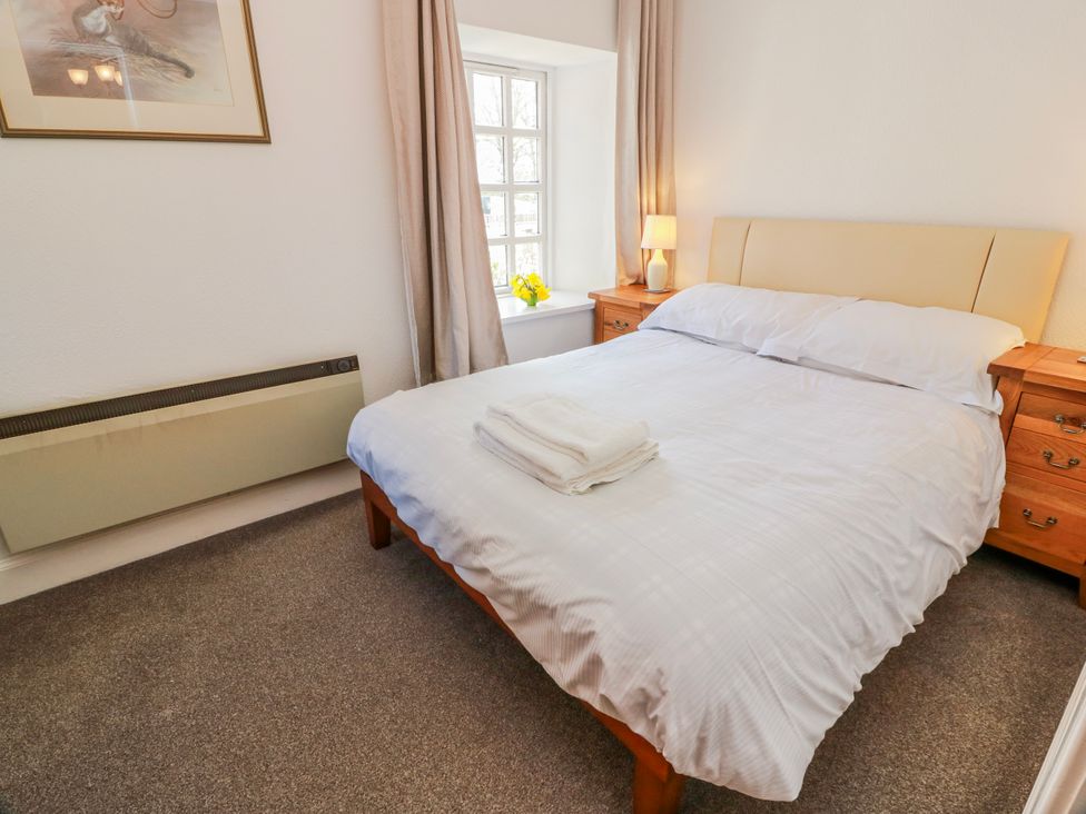 A bedroom with a bed and bedside tables at The Old Coach House in Lockerbie