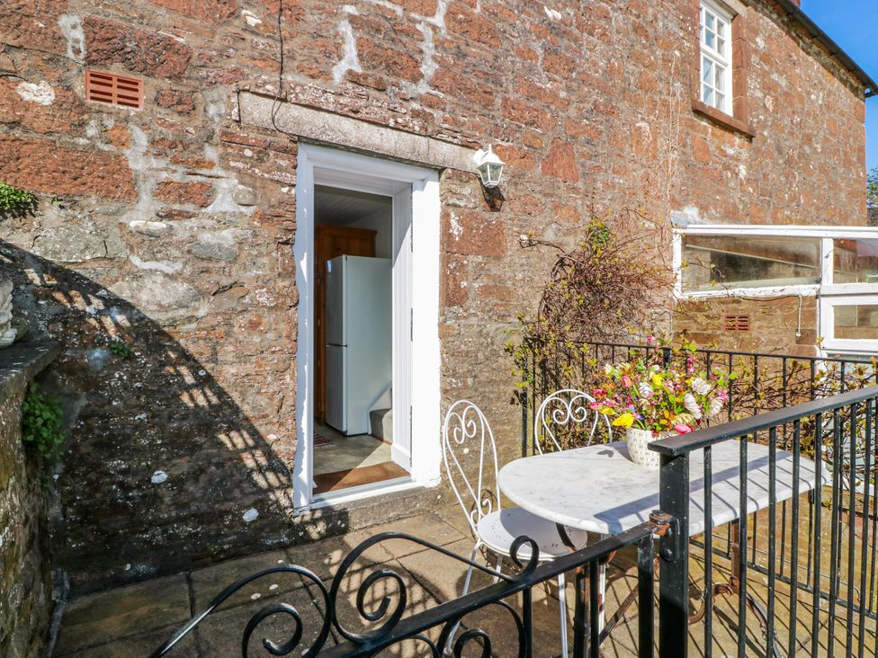 An outdoor seating area with a table and chairs at The Old Coach House Lockerbie
