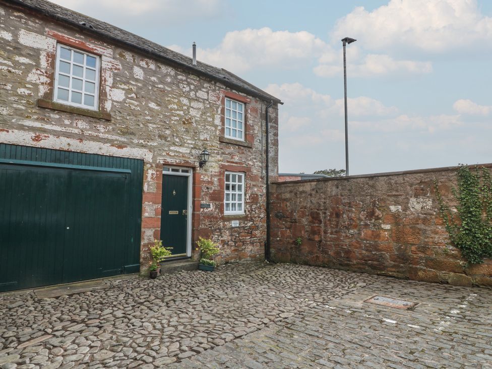 An outdoor area with a stone building and plants at The Old Coach House Lochmaben