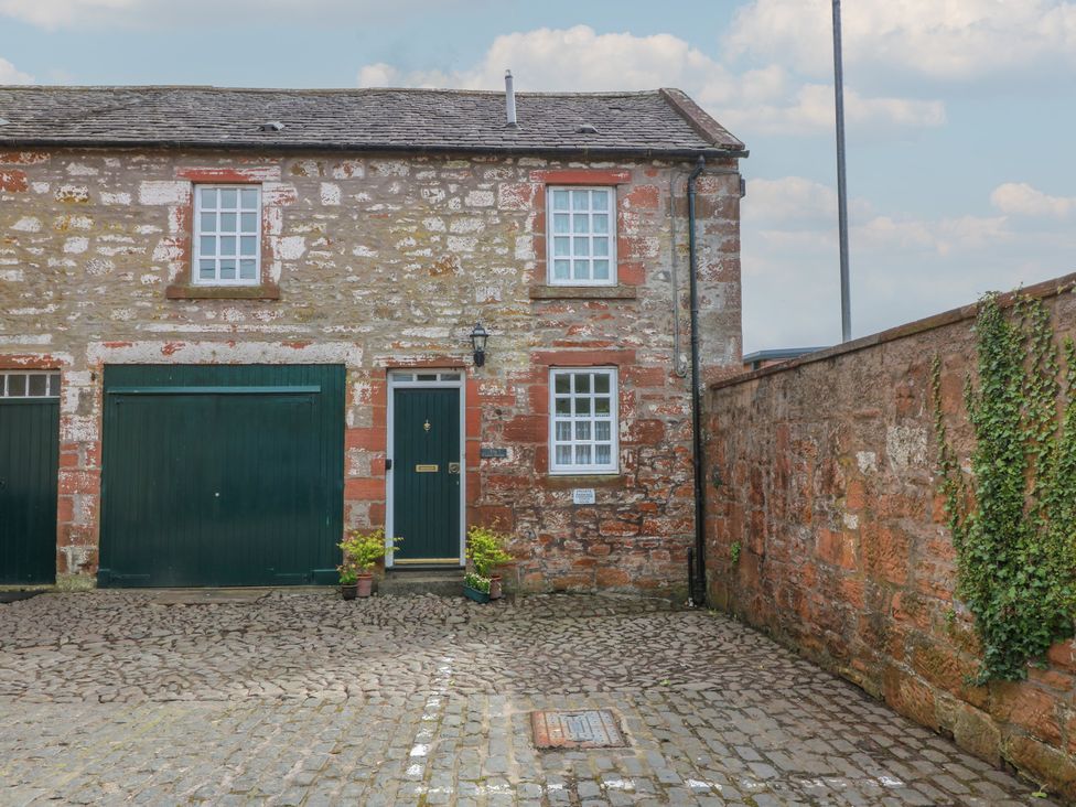 An outdoor area with a building and garage at The Old Coach House in Lochmaben