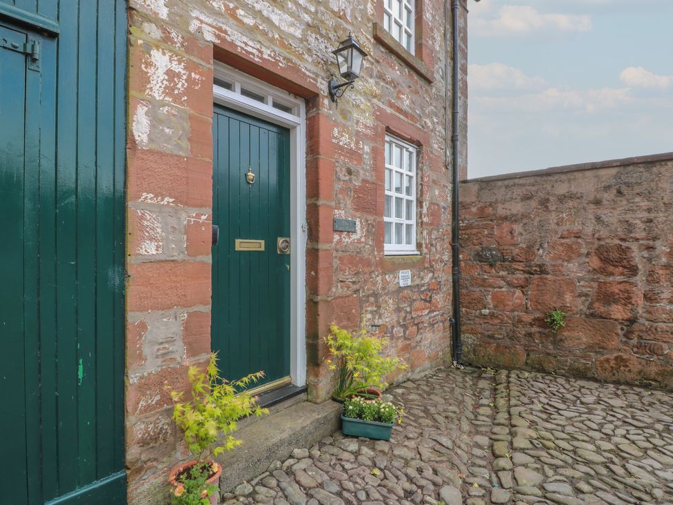 An exterior view of a front door with plants at The Old Coach House in Lochmaben