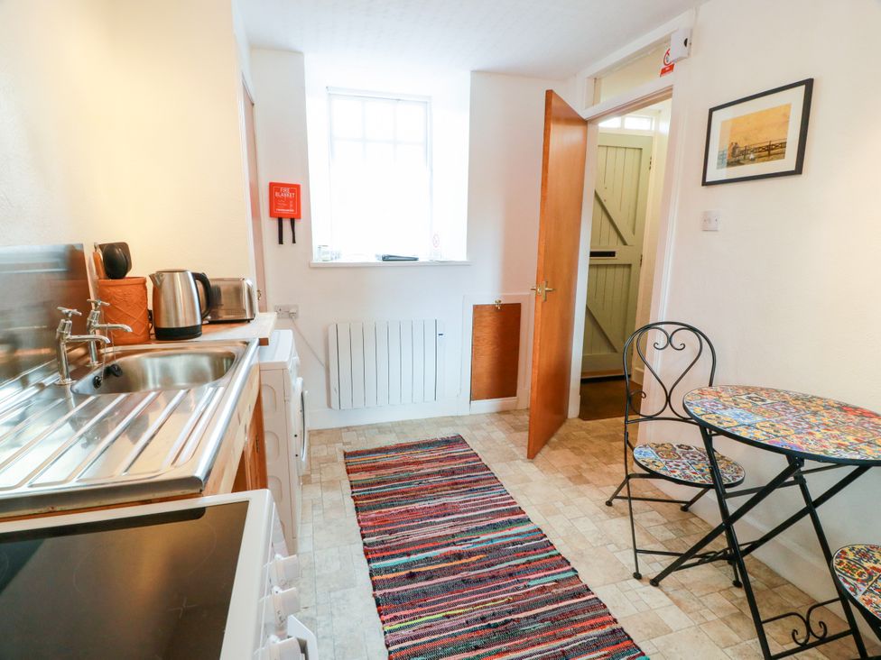 A kitchen with a sink and a table at The Old Coach House in Lochmaben