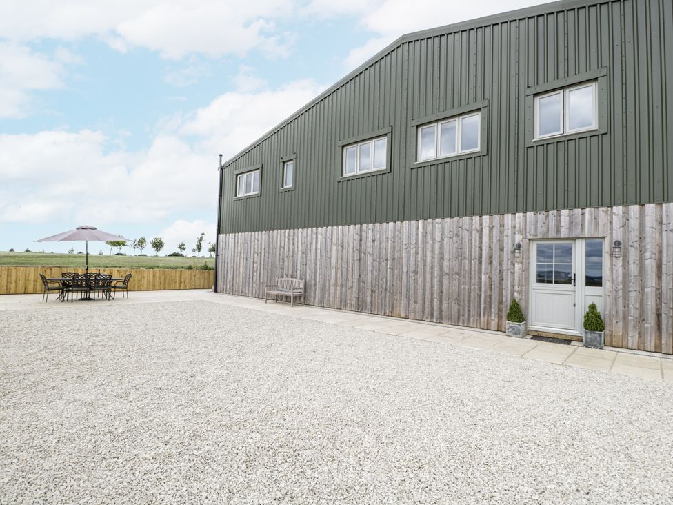 An outdoor area with a building and patio furniture at Hayloft
