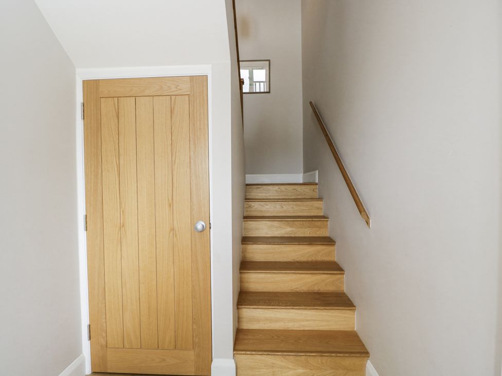 A hallway with a door and stairs at Hayloft