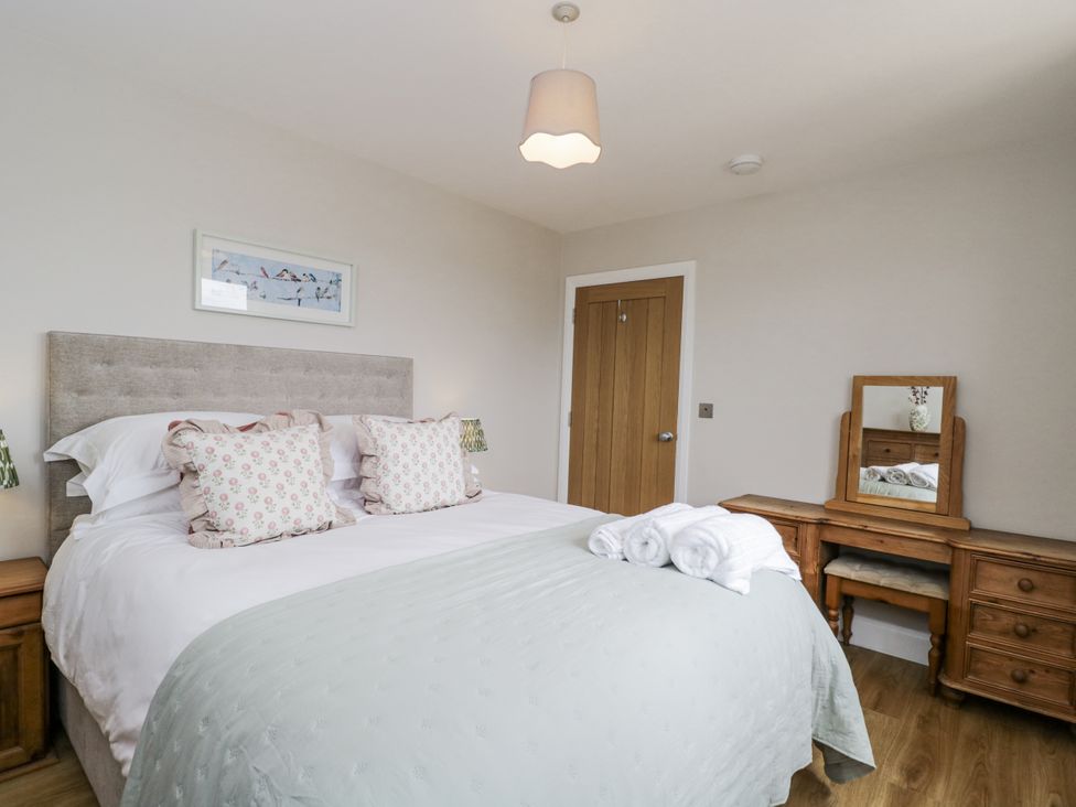 A bedroom with a bed and a dressing table at Hayloft